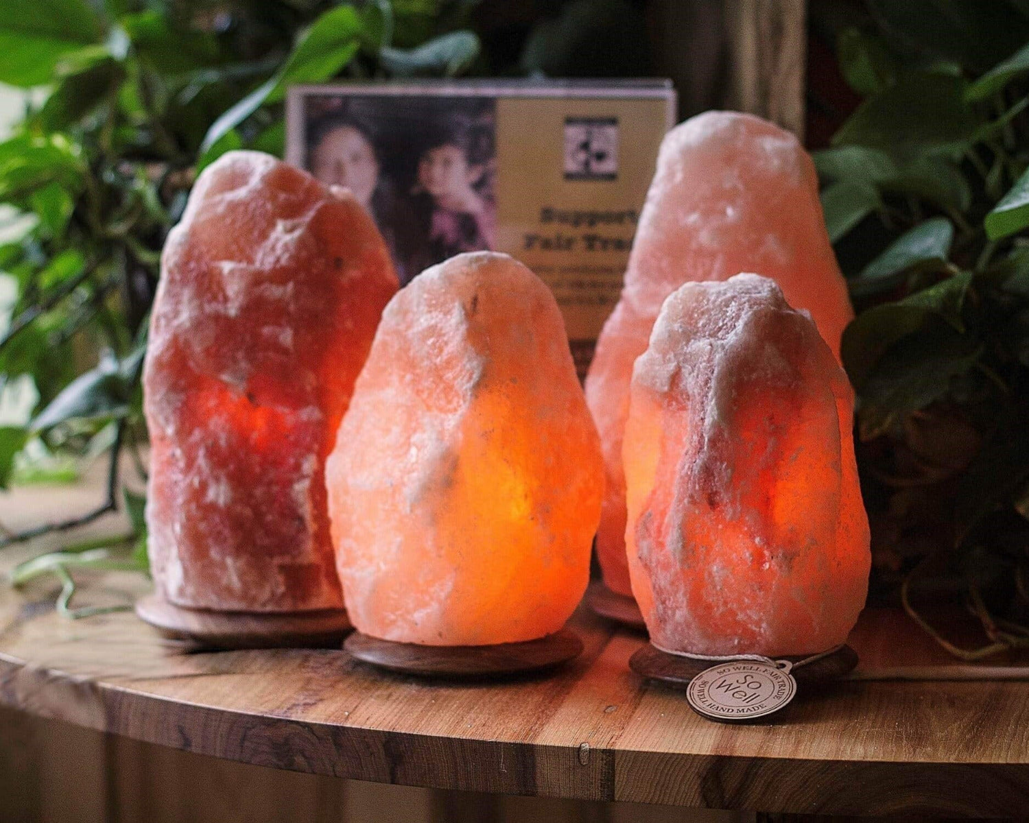 Four Himalayan salt lamps on a wooden surface with a blurred background